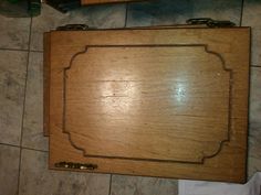 a wooden cutting board sitting on top of a tile floor next to a knife holder