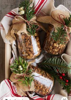 three jars filled with granola sitting on top of a wooden table next to christmas decorations