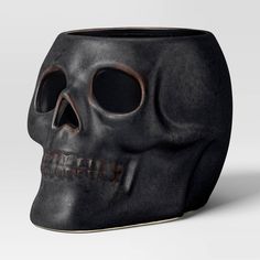 a black vase with a skull on it