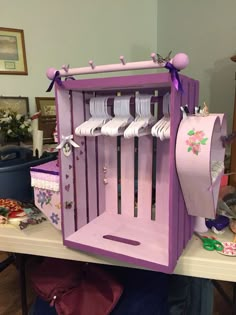 a purple wooden rack with white plates and other items on it, sitting on top of a table