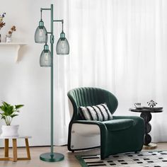 a living room with a green chair and lamp next to a white curtained window