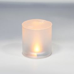 a lit candle sitting on top of a white table