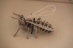 a close up of a metal object with scissors on it's back legs and wings