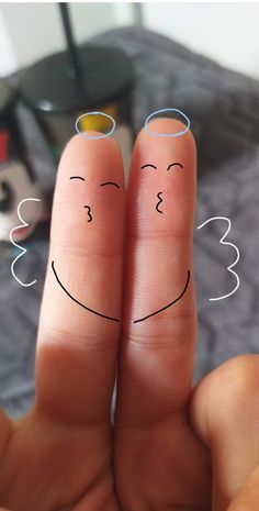 two fingers with faces drawn on them, one is holding the other's thumb