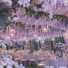 an outdoor wedding setup with purple flowers and chandeliers