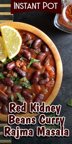 red kidney beans curry in a wooden bowl with lemon wedges and spices on the side