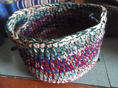 a multicolored basket sitting on top of a wooden table