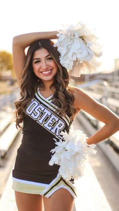 a cheerleader posing for the camera with her pom poms