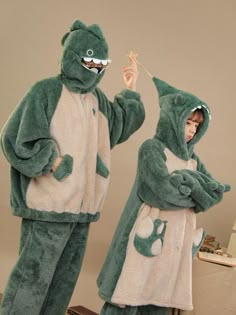 two people in frog costumes standing next to each other, one holding a toothbrush