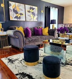 a living room filled with furniture and lots of purple pillows on top of a rug