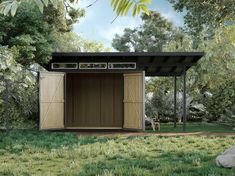 a small black shed sitting on top of a lush green field