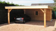 a car is parked in front of a wooden carport with a roof over it