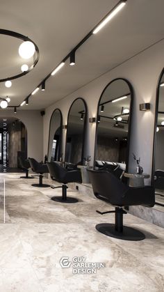 the interior of a hair salon with chairs and mirrors on the walls, lights in the ceiling