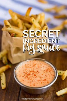 the secret ingredient fry sauce is in a small bowl next to french fries on a wooden table