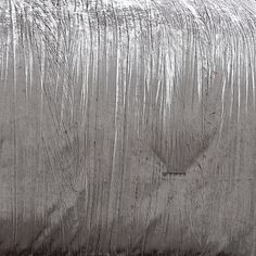 a black and white photo of a bed covered in silver sheeting on the floor