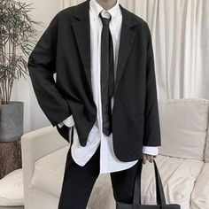 a man in a suit and tie holding a black bag