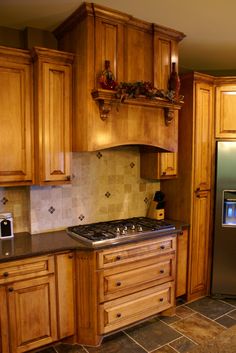 a kitchen with wooden cabinets and tile flooring