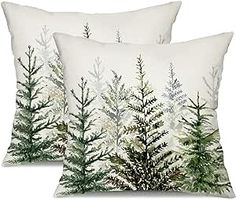 two white pillows with green trees on them