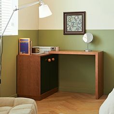 a bedroom with a bed, desk and lamp in it's corner area next to a painting on the wall