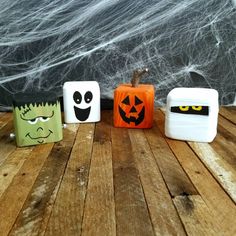 three halloween blocks sitting on top of a wooden table next to a spider web net