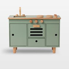 a green cabinet with wooden handles and knobs on the top, in front of a white background