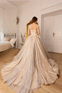 a woman in a wedding dress looking at herself in the mirror