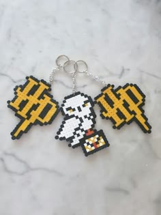 two pixel keychains that have been made to look like video games characters on them