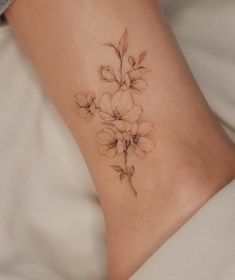 a woman's foot with a flower tattoo on it