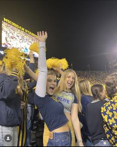 two women in cheerleader outfits at a football game