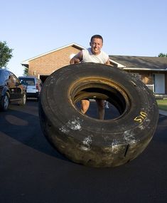 a man is playing with an old tire