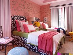 two beds in a room with pink walls and zebra print on the bedding,