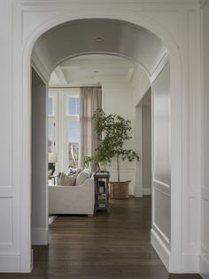 an archway leading to a living room with a couch and coffee table in the center