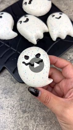 a person is holding some fake ghost cookies