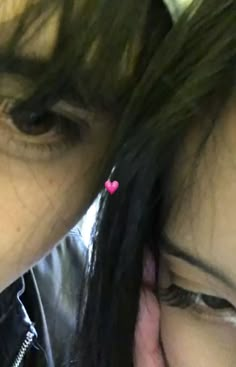 two women with black hair and pink hearts on their ear