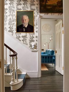 an old man in a suit and tie is on the wall next to a staircase