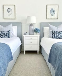 two beds with blue and white bedding in a bedroom