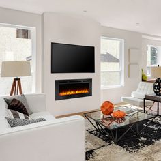 a living room with white furniture and a flat screen tv mounted above the fire place