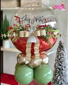 a christmas ornament sitting on top of two balls in front of a tree