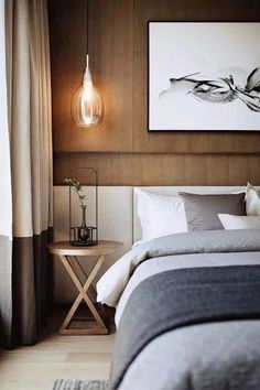 a bedroom with wood paneling and white bedding, an art work on the wall