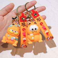 three cartoon key chains in the palm of someone's hand