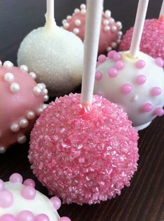 cake pops with pink and white sprinkles are on a table next to each other