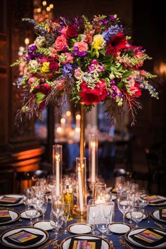 a tall vase filled with colorful flowers on top of a table