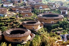 an aerial view of several circular buildings in the middle of a forest with trees around them