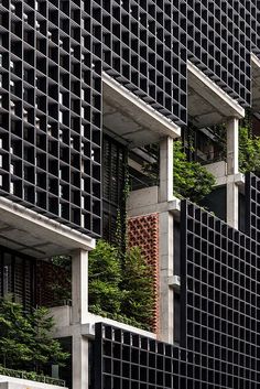 the side of a building with many windows and plants growing on it's sides