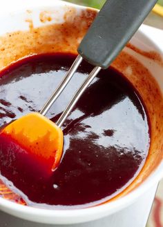 a bowl filled with red liquid and a whisk in it