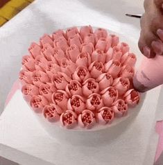 a cake decorated with pink flowers on top of a white tablecloth covered in paper