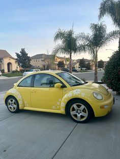 a yellow car parked in front of a palm tree