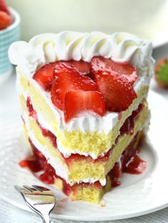 a piece of cake with strawberries on top is sitting on a plate next to a fork