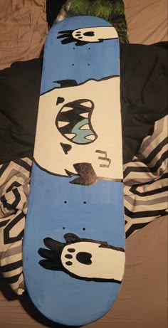 a painted snowboard laying on top of a bed