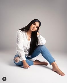 a woman sitting on the ground with her legs crossed